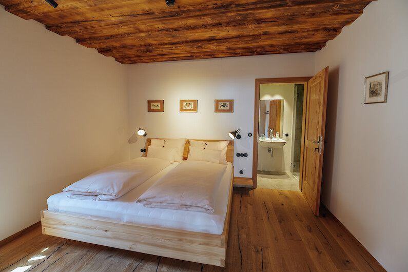 Schmiedgut - Platzhirsch - Gemütliches Schlafzimmer mit Holzdecke und warmem Holzboden