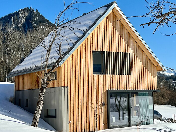 Schmiedgut - Wald und Wiese - Außenansicht auf das Design-Ferienhaus in der Wintersonne